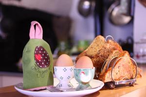 埃克塞特Brook Farmhouse的盘子里放鸡蛋和面包的桌子