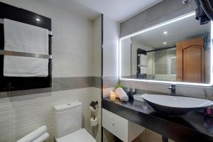 奥莱罗斯apartamento santa cruz oleiros的一间带水槽、卫生间和镜子的浴室