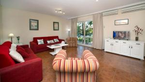 伊斯兰蒂拉伊斯拉玛狮子公寓的客厅配有红色的沙发和椅子