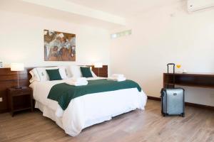 布宜诺斯艾利斯Hotel 6 de Octubre的一间卧室配有一张大床和一个行李箱