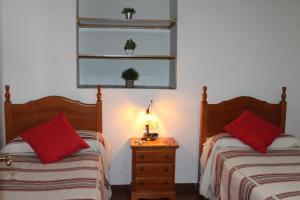 卡皮雷拉Manzanilla Real的一间卧室配有两张床和床头灯。
