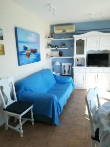 库列拉apartamento junto al mar的客厅配有蓝色的沙发和电视