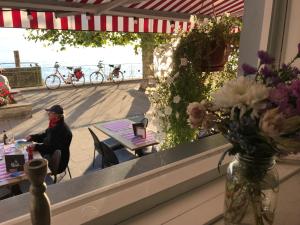 梅尔斯堡海滨长廊酒店的坐在窗前桌子上的女人