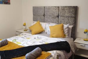 柯科迪The Beach Apartment, near Outlander location的一间卧室配有一张带黄色枕头的大床
