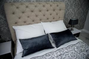 皮拉Glamour Apartments的一张带黑白枕头的床