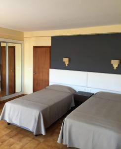 波多诺伏Hotel Nuevo Cachalote的一间卧室设有两张床和黑色的墙壁