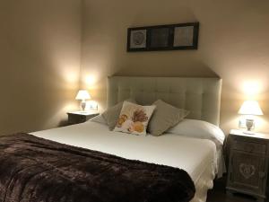 布拉内斯La Magnòlia i L´Alzina的一间卧室配有一张带2个床头柜的大型白色床