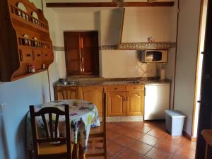 ArancedoApartamentos Rurales Casa Caleya的厨房配有桌子和白色冰箱。