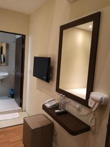 关丹季节景观酒店的浴室设有镜子,柜台上设有电话