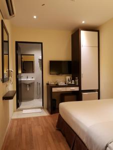 关丹季节景观酒店的一间卧室配有一张床,浴室设有水槽