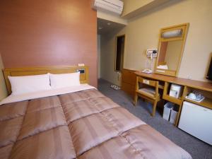 山形市山形站前路线酒店的酒店客房设有一张大床和一张书桌。