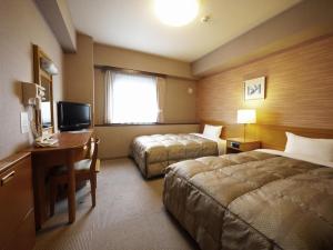 山形市山形站前路线酒店的酒店客房设有两张床、一张桌子和一台电视。