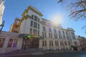喀山哈雅尔酒店的一座白色的大建筑,后面有太阳