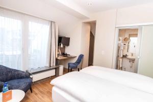 苏黎世雷克斯速乐酒店的酒店客房设有床、沙发和窗户。