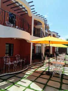 马查科斯Machakos Suites Luxury Hotel的一座带桌子和遮阳伞的庭院