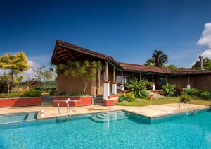 马迪凯里库格遗产度假酒店的房屋前有游泳池的房子