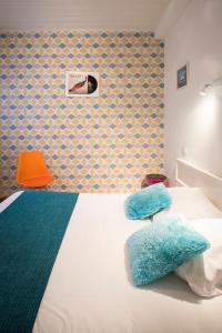 拉罗谢尔巴黎酒店的一间卧室配有一张床和一张橙色椅子