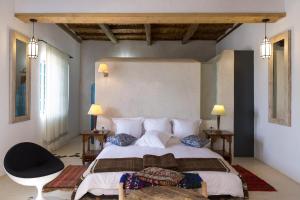 索维拉Riad Tamayourt Ocean View & piscine chauffée à 30的一间卧室配有一张大床和一张黑椅