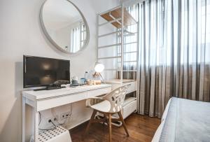 楼尔Loulé Coreto Guesthouse的一间卧室配有一张桌子、一台电视和一面镜子