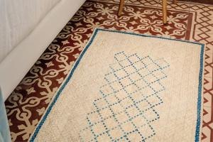 楼尔Loulé Coreto Guesthouse的一间房间里地板上的十字缝地毯