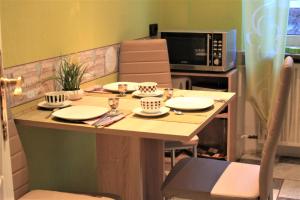 美因茨MA-LIVING Villa Elenor的厨房配有带盘子和微波炉的桌子