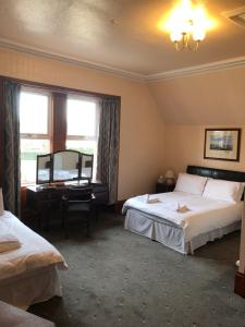 奈恩Westerlea Hotel Nairn的酒店客房设有两张床和窗户。