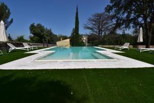 格罗塔费拉塔葛拉索利公园别墅酒店的草坪中间的游泳池,带椅子