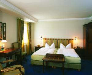 劳芬堡布鲁切什雷贝斯托克酒店的酒店客房,配有一张带白色床单和一张桌子的床。