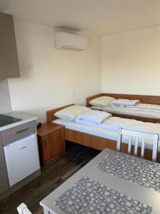 马里博尔Apartman Decorus的配有桌子和厨房的客房内的两张床