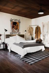 马德里room00 Chueca Hostel的卧室配有一张大床,墙上挂有绘画作品