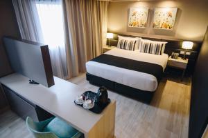 布宜诺斯艾利斯GrandView Hotel Buenos Aires的配有一张床和一张书桌的酒店客房
