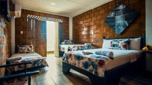 努基Hotel Acuali Nuqui的一间卧室配有两张床和椅子