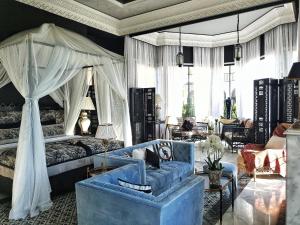 马拉喀什Palais Ronsard Relais & Chateaux的一间卧室配有蓝色的沙发和天蓬床