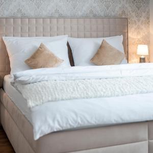 伊赫拉瓦HOME 223 - designový apartmán的一张配有白色床单和枕头的大床