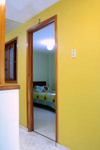 波哥大Hostel Casa Alb的一间房间,设有通往卧室的门