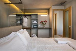 卡拉马基Icarus Hotel的卧室配有白色的床和衣柜。