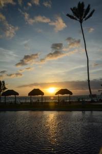 嘎林海斯港Ancorar Porto de Galinhas Flats的海滩上的日落,带遮阳伞和游泳池