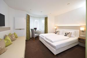 林登贝格拜耶里斯彻酒店的卧室配有一张白色大床和一张书桌