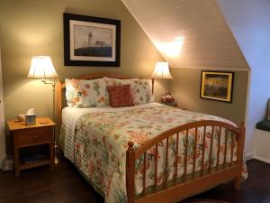 Ilwaco海港乡村宾馆的一间卧室配有一张床和两盏灯。