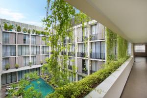 勒吉安库塔露台酒店的公寓大楼拥有绿色的外观,设有游泳池