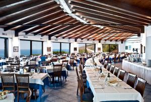 卡梅罗塔码头幸福村酒店的用餐室设有桌椅和窗户。