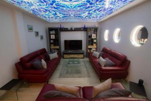 厄尔梅达诺MEDANO4YOU Casa Violeta的客厅设有红色的沙发和蓝色的天花板