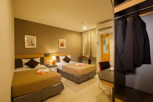 吉隆坡LEO快捷酒店 的酒店客房,设有两张床和一张沙发