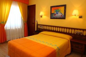 阿兰扎达哔波酒店的一间卧室配有一张带橙色毯子的床
