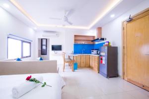 岘港Sincero Hotel & Apartment的厨房以及带沙发和冰箱的客厅。