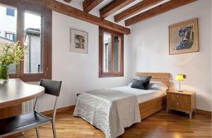 威尼斯Salmaso Apartments的一间卧室配有一张床和一张桌子及椅子