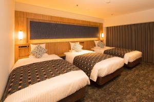 盛冈Art Hotel Morioka的一间酒店客房,房间内设有三张床