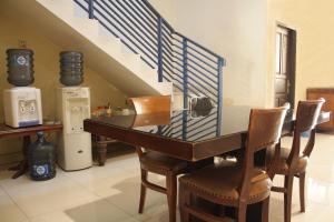 雅加达RedDoorz near Tomang 2的一间带桌椅和楼梯的用餐室