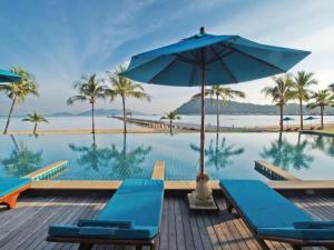 象岛Point of view condos, tranquility bay, koh chang的一个带蓝色椅子和遮阳伞的游泳池