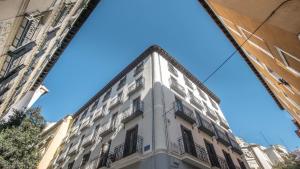马德里Soho Boutique Opera的一条高大的白色建筑,在街上设有阳台